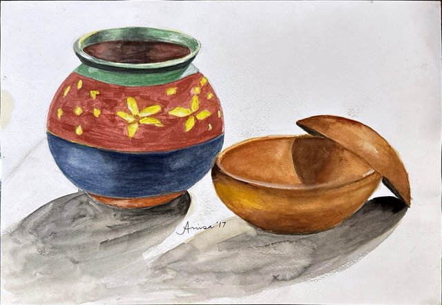 A round pot painted in red, blue and yellow stands beside a wooden bowl with its lid tilted open.